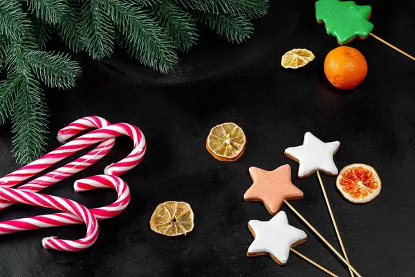 Dark Christmas background with gingerbread and candy lollipops (Flip 2019)