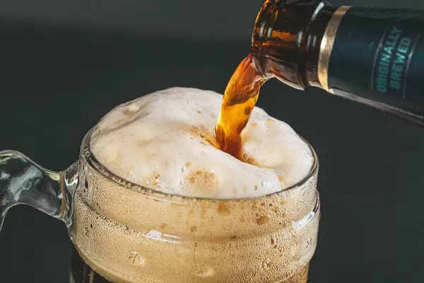 Dark fresh beer poured into glass, close up