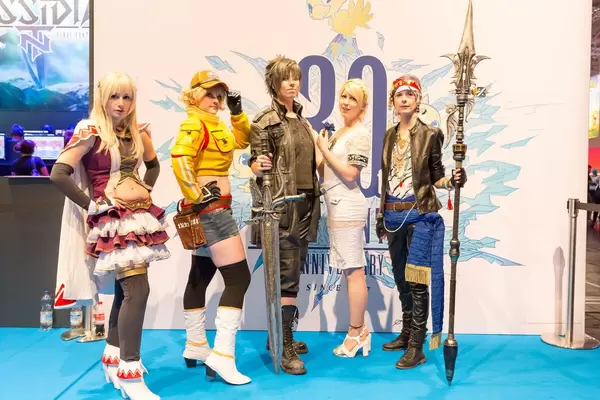 Darstellerinnen posieren vor dem Plakat FINAL FANTASY 30th Anniversary - Gamescom 2017, Köln