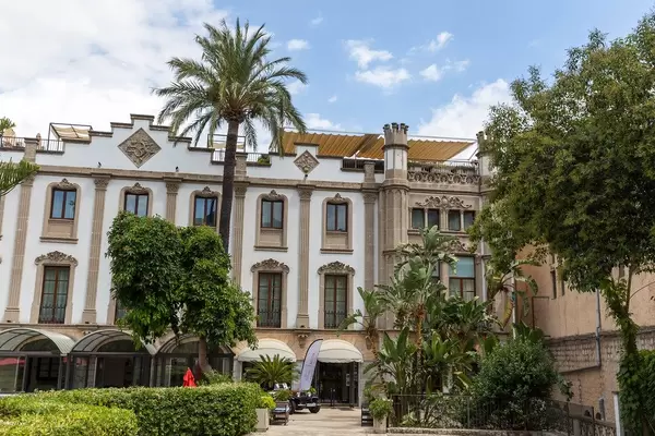Das Gran Hotel Sóller. 5-Sterne Hotel auf Mallorca. Das weiße Gebäude mit Palmen vor dem Eingang