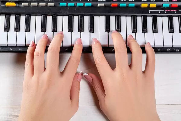 Das Mädchen spielt einen kleinen Synthesizer