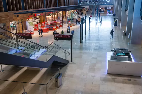 Das Terminal 1 vom neuen Flughafen BER: Heinemann Duty Free und Personen mit Mundschutz