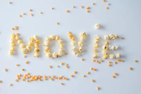 Das Wort ‘Movie’ geschrieben mit Popcorn vor weißem Hintergrund