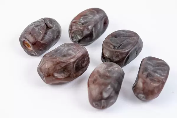 Date palm fruits above white background