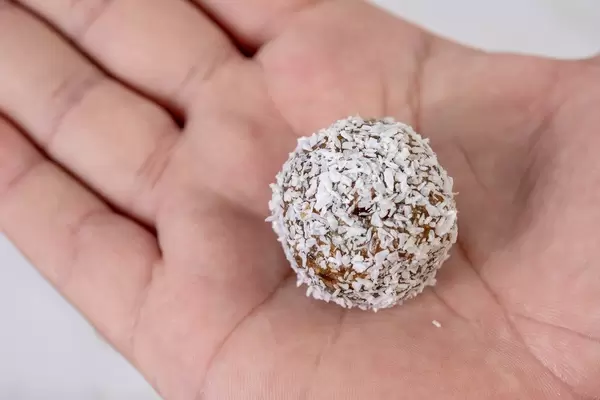 Dates and Peanut Butter energy balls in the Coconut on the hand (Flip 2019)