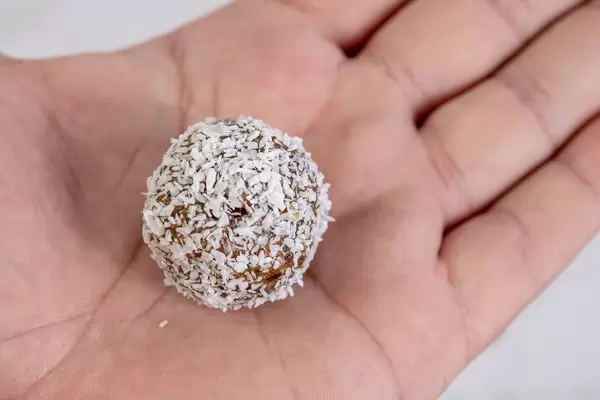 Dates and Peanut Butter energy balls in the Coconut on the hand