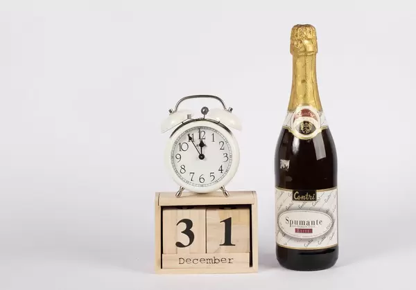 Day 31 of December set on wooden calendar with champagne bottle