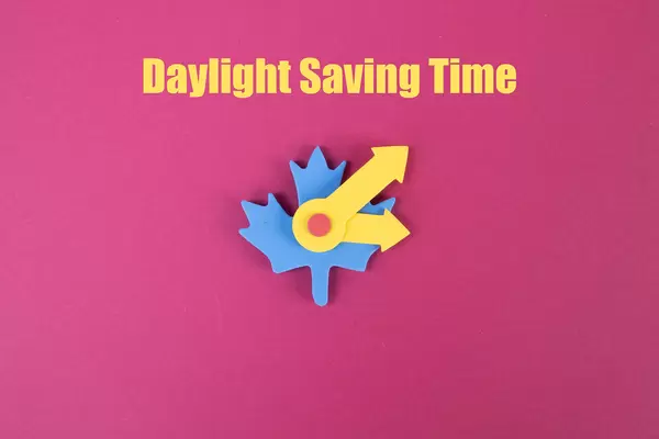 Daylight Saving Time text with clock on pink background