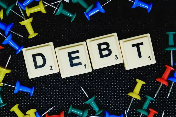 Debt (Schuld) Text auf flachem Untergrund fotografiert