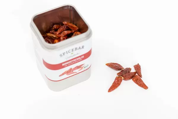 Deckeldose von Spicebar Gewürzküche beinhaltet getrocknete Birdseye Chili-Schoten, zum Schärfen von Gerichten, auf weißem Untergrund