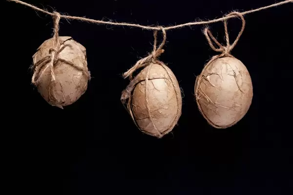 Decorated Easter eggs hanging on a rope against the black background