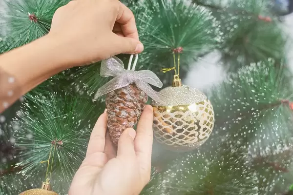 Decorating a Christmas tree with toys and pine cones