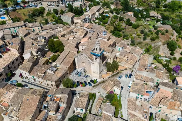 Decorations and cars parked in front of the Sant Bartolomeu church in Valldemossa. Aerial view