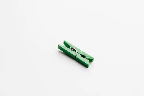 Decorative green wooden clip on white background