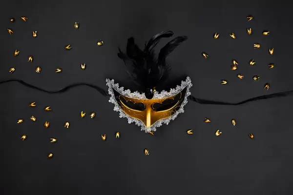 Decorative venetian mask with feathers on black background