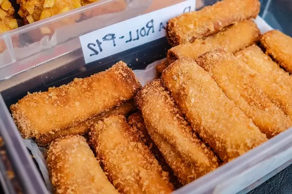 Deep fried ham and cheese rolls in container