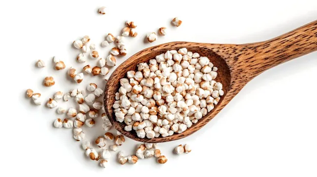 Dekorativ angeordnete Buchweizenkörner in hölzernem Löffel