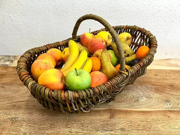 Dekorativer Flechtkorb mit saisonalem Obst im Herbst