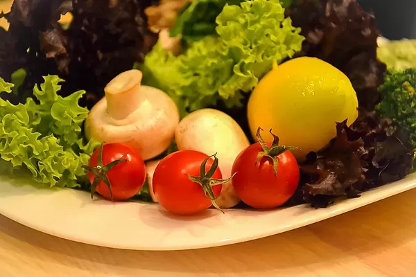 Dekorativer, kunstvoller Salatteller mit Pilzen und Tomaten