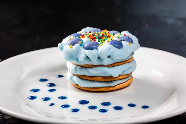 Delicious dessert with blue cream on a white plate