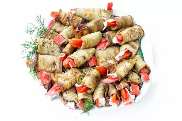 Delicious eggplant rolls on a white plate. Top view