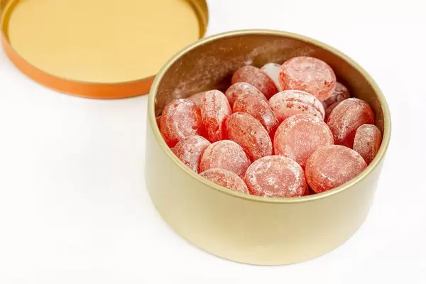 Delicious Fruit Candies in the box above white background