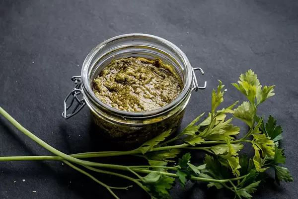 Delicious green pesto in a glass jar.