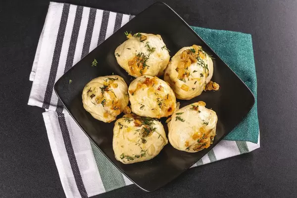 Delicious homemade dumplings with fried onions and dill, top view