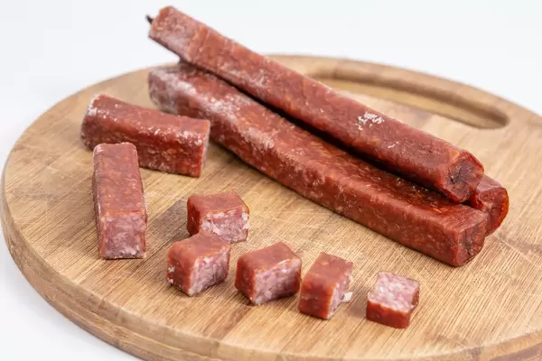 Delicious Hunting Sausage sliced and served on the wooden board