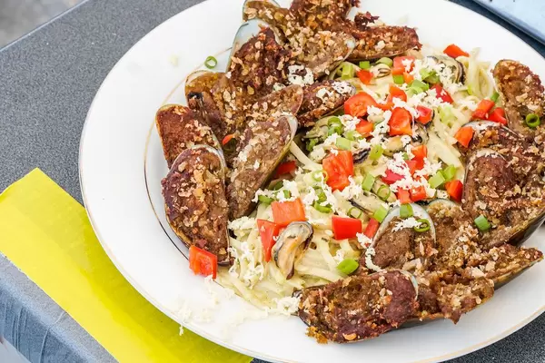 Delicious mussel pasta dish on gray surface (Flip 2019)