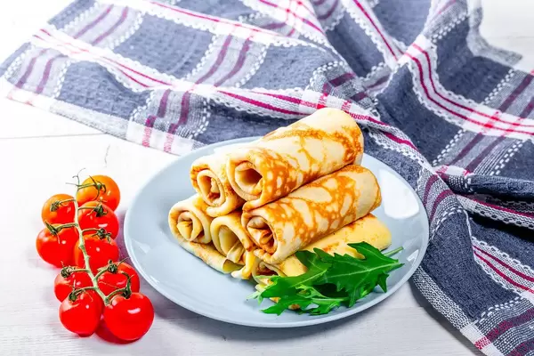Delicious pancakes on a plate with cherry tomatoes