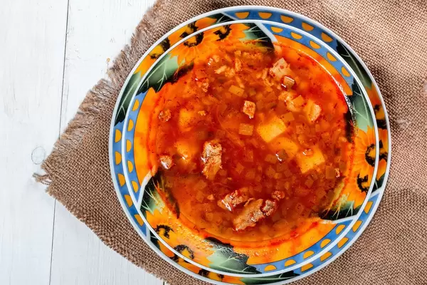 Delicious pickle soup with meat, potatoes, rice, pickles and tomato sauce on burlap