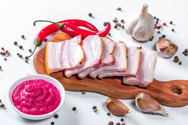 Delicious smoked slab bacon with spices and chili on a cutting block