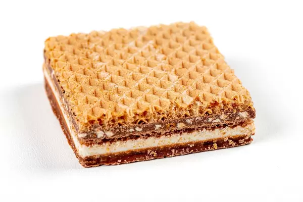 Delicious waffle with chocolate and nuts on a white background (Flip 2020)