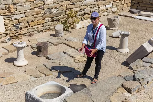 Delos, Greece: tour guide wears transparent shield covering mouth and nose as protection from Covid19