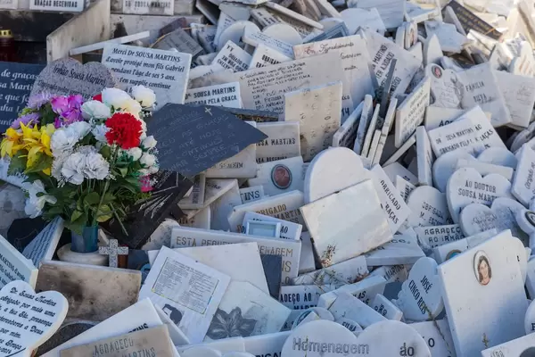 Denkmäler mit Blumen am Fuße der Jose Thomas de Sousa Martins Statue