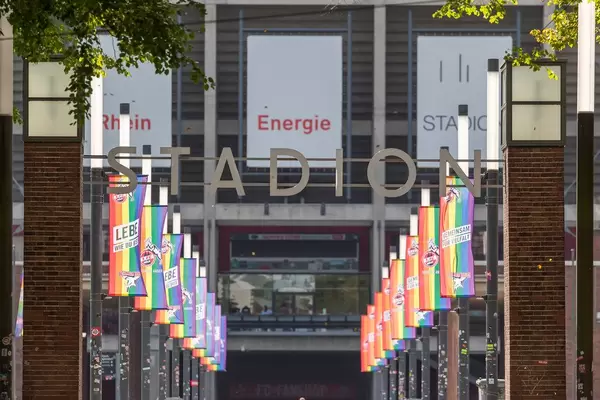 Der Eingang vom Rheinenergie Stadion mit regenbogenbunten Fahnen