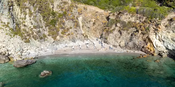 Der schmale Kiesstrand von Agios Ioannis auf Skopelos mit türkisfarbenem Meer, von Felsen umgeben