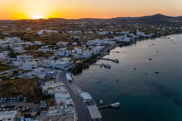 Der Sonnenuntergang in Adamantas, Hafenstadt auf Milos. Luftbild mit weißen Häusern und Booten