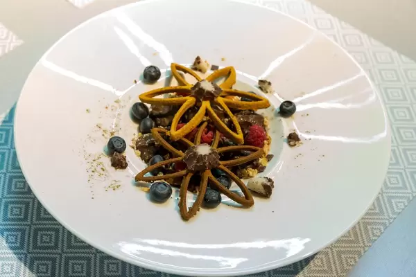 Dessert with blueberries, raspberries and chocolate with beautiful cookies in flower shape