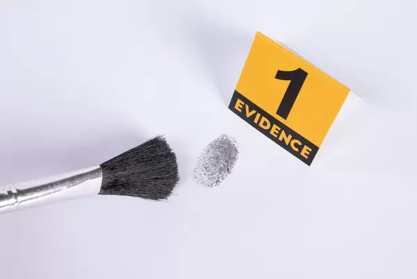 Detective using powder and brush to take fingerprint