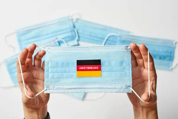 Deutsche Flagge mit Abstimmungstext auf medizinischer Gesichtsmaske