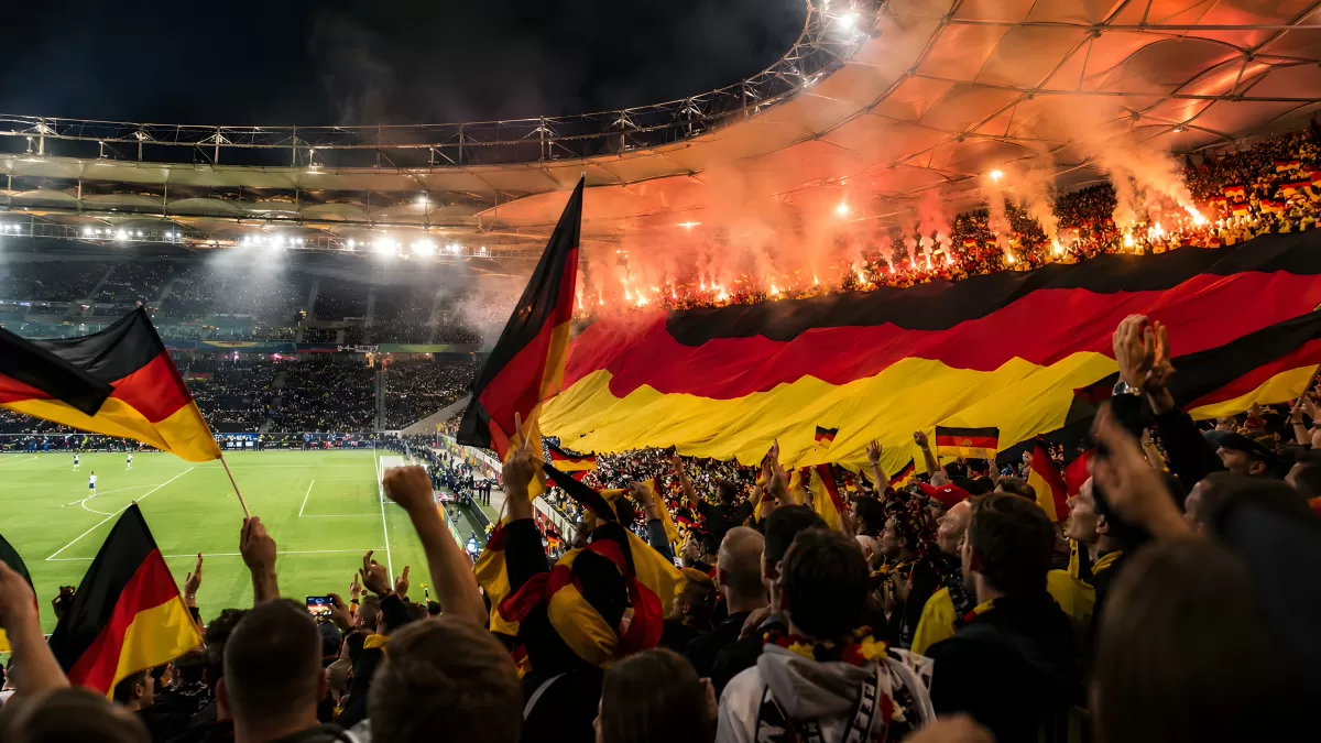Deutsche Fußballfans feiern mit Flaggen im Stadion