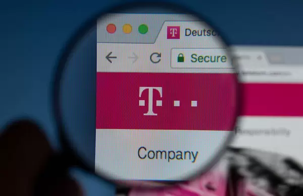 Deutsche Telekom Logo am PC-Monitor, durch eine Lupe fotografiert