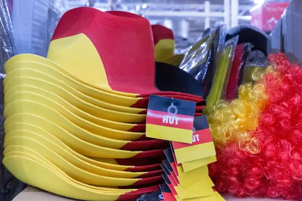 Deutschland Fanartikel - gestapelte Hüte, verpackte Fahnen und Perücken