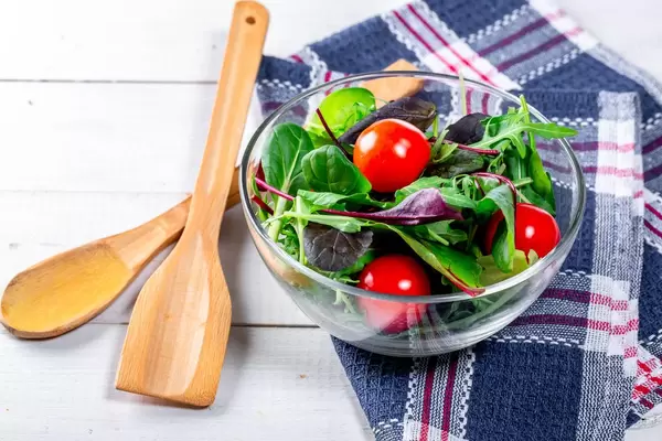 Diät-Salat mit Kräutern und Kirschtomaten in einer Glasschüssel