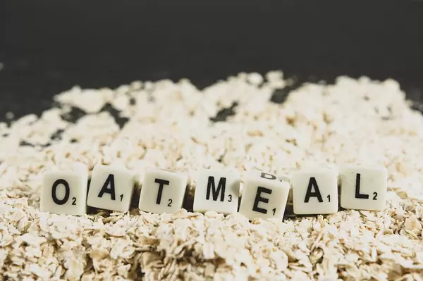 Dice reading OATMEAL over oats