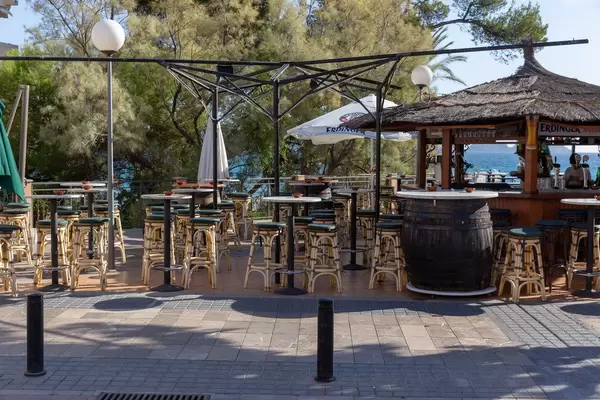 Die Barhocker einer Bar mit Meerblick an einer Promenade auf Mallorca