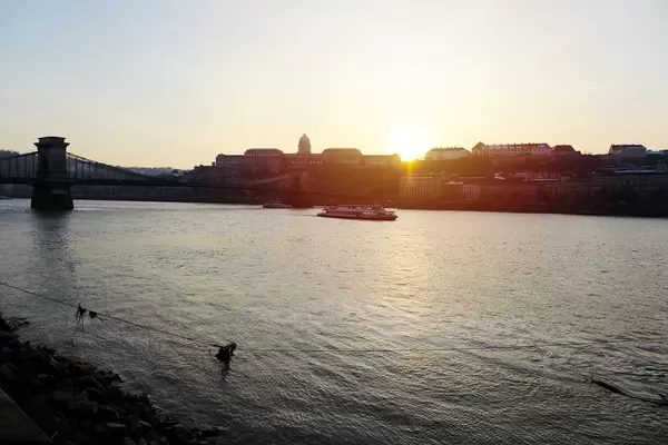 Die Donau in Budapest, Ungarn, mit Sonnenuntergang hinter den Häusern der Stadt