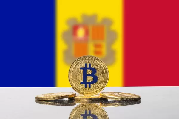Die Flagge Andorras und vier goldene Bitcoins im Vordergrund mit Tiefenschärfe fotografiert